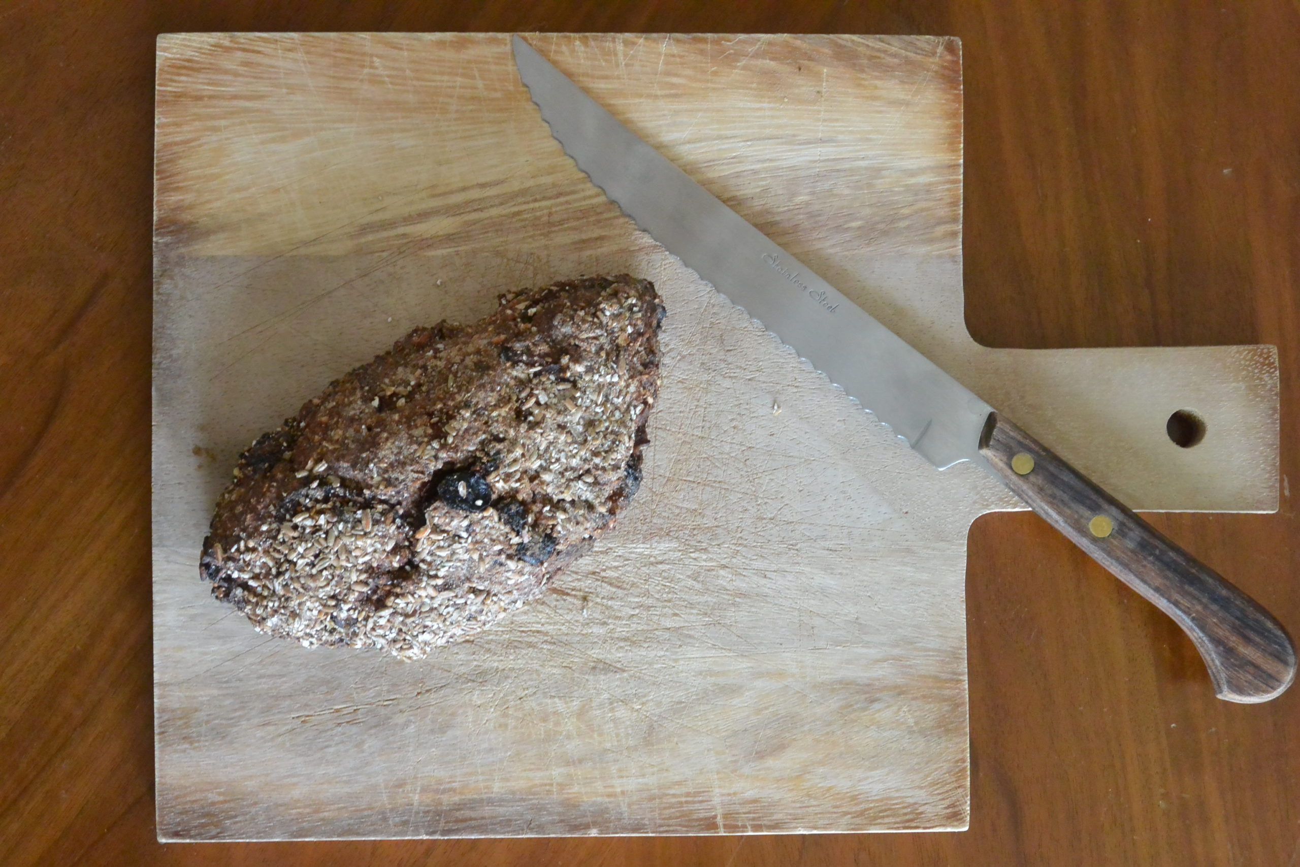 Roggen-Früchte-Brot auf Holzbrett mit Messer